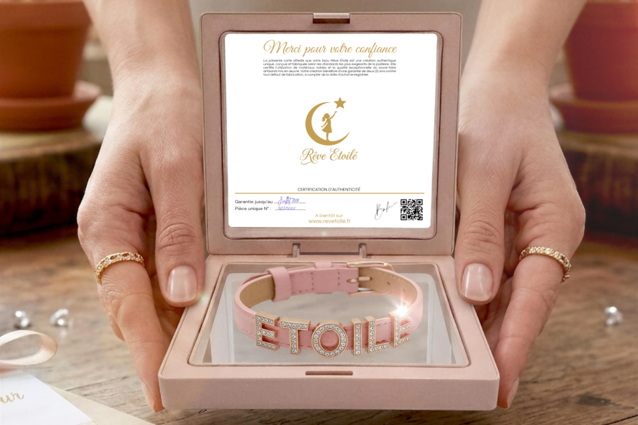 Coffret cadeau Rêve Étoilé ouvert dévoilant un bracelet personnalisé en cuir véritable rose poudré avec des lettres coulissantes en strass, 